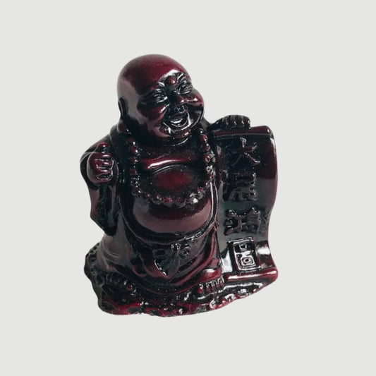 Glossy red Buddha figurine on a white background
